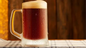 Ein Bierkrug steht auf einem Tisch, leicht beschlagen.