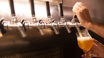 Tap fills glass with beer in a bar.