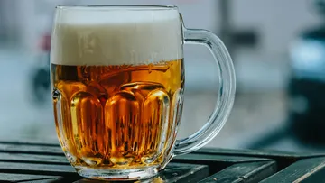 Ein Krug mit Bier steht auf einem Tisch.
