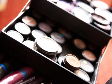 Black box with various makeup cans in a room