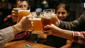 Glasses toast to party in a bar.