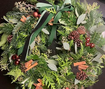 Ein Weihnachtskranz liegt dekoriert auf einem Tisch.