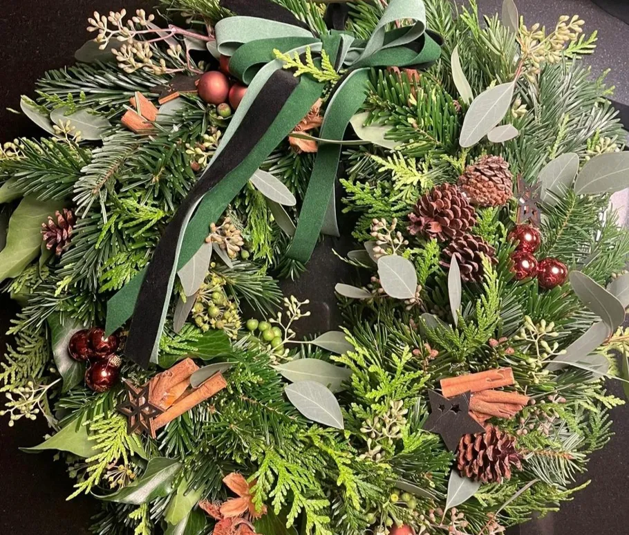 A Christmas wreath is decorated on a table.