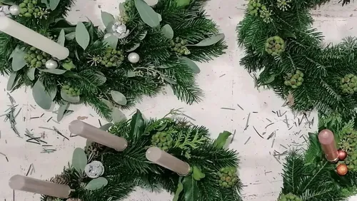 Drei Adventskränze mit Kerzen und grünem Tannenzweigen.