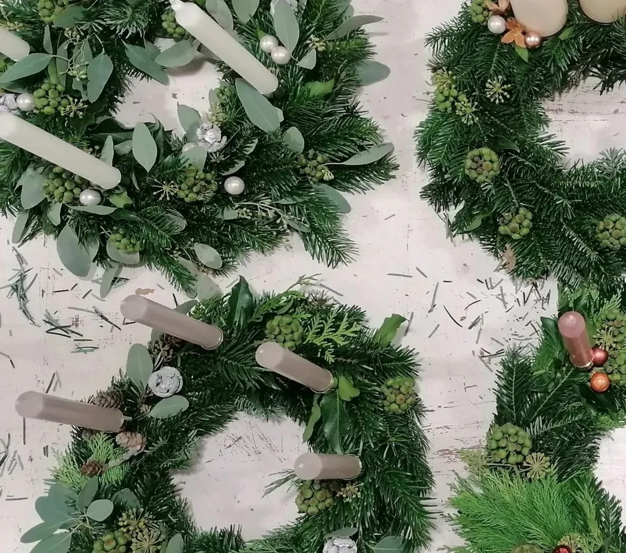 Three advent wreaths with candles and green pine branches.