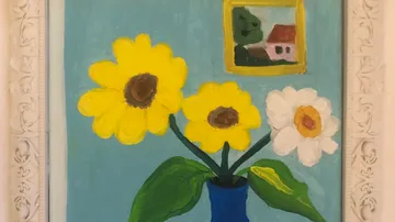 Gelbe und weiße Blumen in blauer Vase vor blauem Hintergrund.