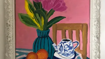 Flowers in a vase, teapot and oranges on table.