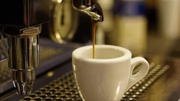 Kaffeetasse füllt sich mit frisch gebrühtem Espresso.