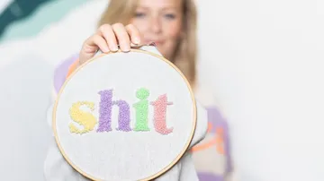 Ein Rahmen zeigt das eingestochenen Wort "shit", gehalten von einer Person.