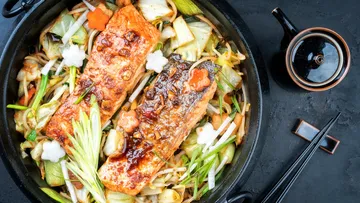 Gegrillter Lachs auf Gemüse in einer Schüssel, appetitlich angerichtet.