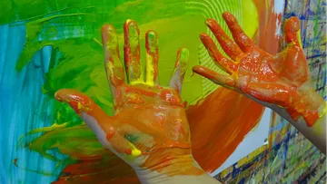 Bunte Hände malen lebendige Farben auf eine Leinwand.