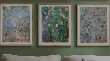 Three framed floral paintings on green wall.