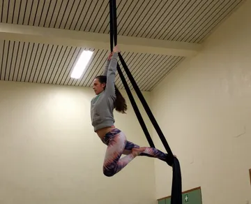 Frau schwingt in Tuch während des Trainings in der Halle.