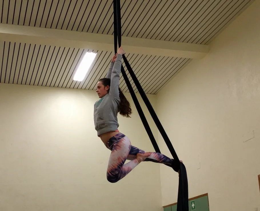 Woman swings in cloth during exercise in the hall.