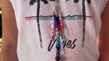 Pearl necklace hangs from t-shirt, personalized with name
