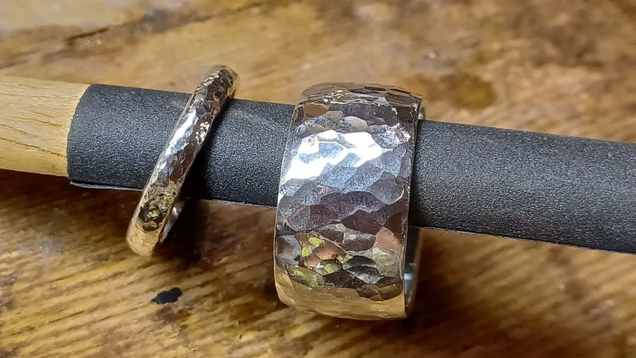 Two hammered silver rings on a rod.