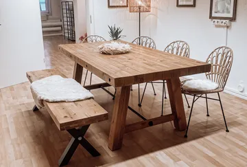 A wooden table and benches are placed in a bright room.
