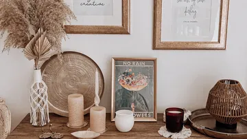 Decorative arrangement with candles, pictures and plants.