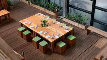 Wooden table with chairs, covered in a green interior.