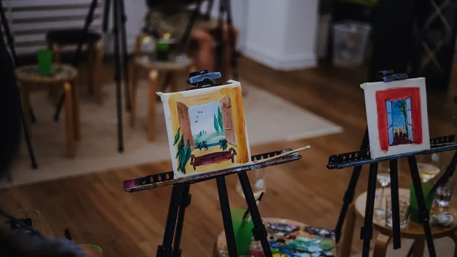 Two easels with paintings in an interior.