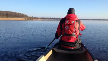 Paddelndes Kajak im ruhigen Wasser eines Sees.