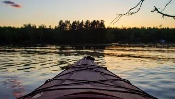 Kajak auf Wasser, sanftes Gleiten bei Sonnenuntergang.