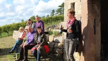 Eine Gruppe von Personen sitzt und steht im Freien.