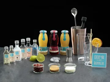 Cocktail ingredients are laid out on a dark surface.