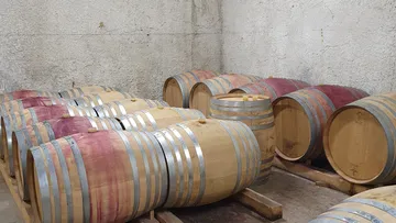 Fässer lagern in einem weinproduzierenden Keller.
