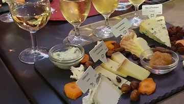 Cheese platter served with wine, nuts and dried fruit.