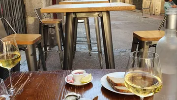 Tisch mit Getränken und Essen in einem Straßencafé.