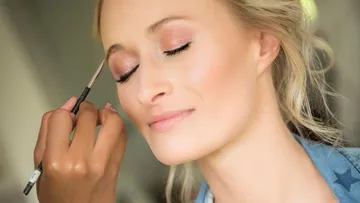 Eine Frau erhält Make-up im sanften Licht.