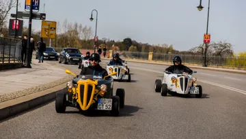 Three cars are driving along a road.