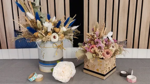 There are two flower arrangements on a table.