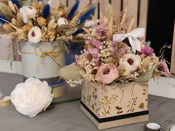Colourful, dried flower arrangements are placed on a table.