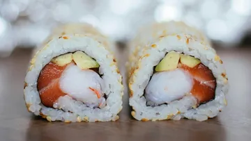 Sushi rolls are cut in half and show fresh filling.