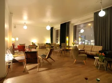 Cosy room with various seating areas and soft lighting.