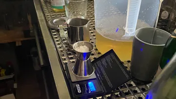 Weighs ingredients on a work surface in a bar