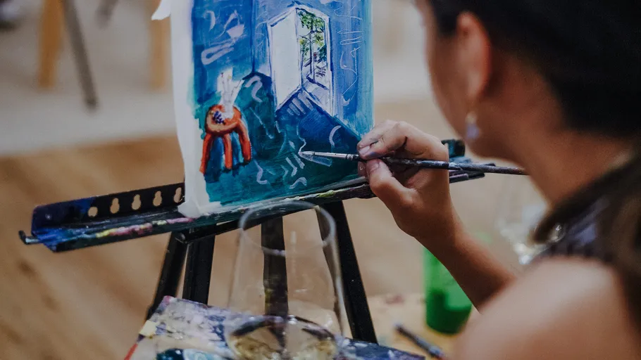 An artist paints a colorful scene on a canvas.