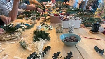 Tables with various materials for floral arrangements and snacks.