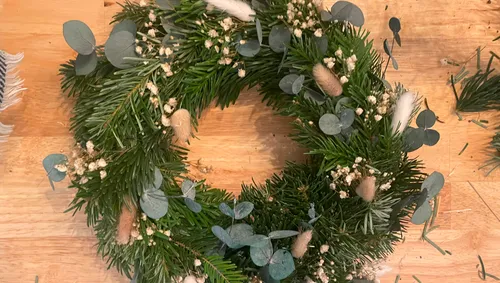 Wreath of pine branches with eucalyptus and dried flowers.