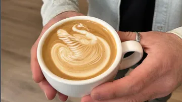 Cup of coffee showing a swan in the milk