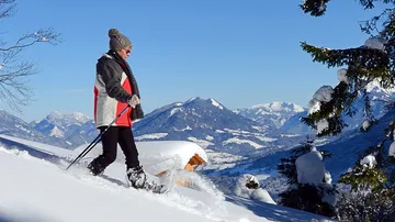 A person is hiking in the snow in the mountains.