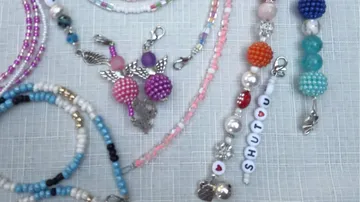 Colourful pearl necklaces lie on a bright background.