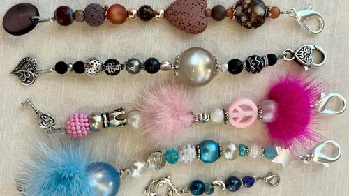 Colourful necklaces made of various materials lie on fabric.