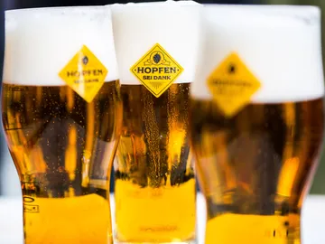 Drei Gläser Bier stehen nebeneinander auf einem Tisch.