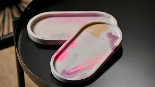 Two colored trays lie on a black table.