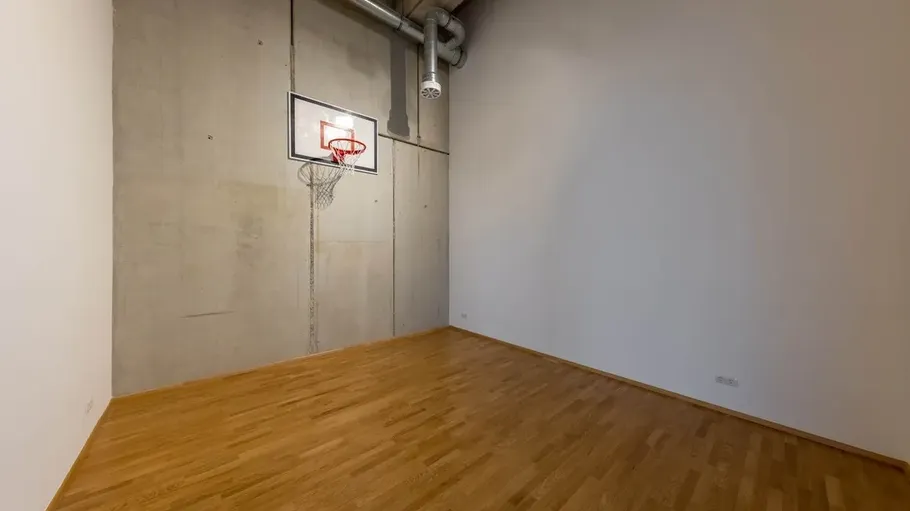 Basketballkorb hängt an einer Wand in einem leeren Raum.