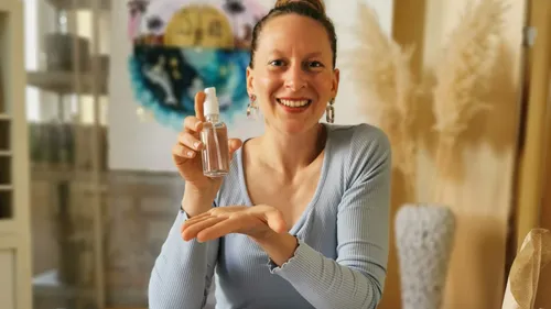 Person, die drinnen eine Sprühflasche hält.