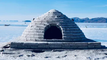 Salt ice house stands in front of a vast, snow-covered landscape.